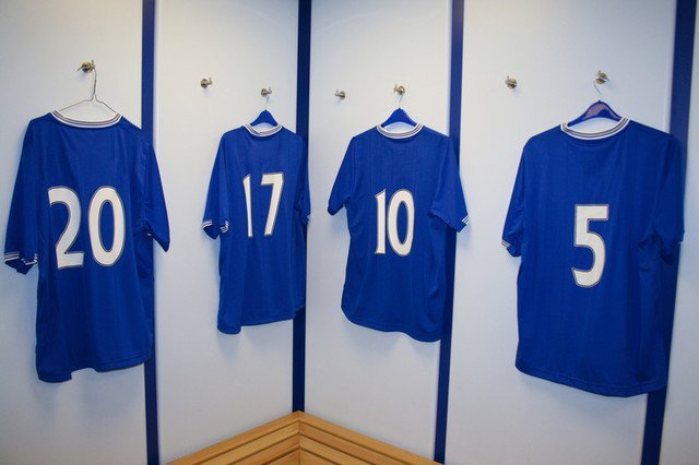 Royal blue football shirts on hangers, with the numbers 20, 17, 10 and 5 in white